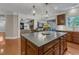 Spacious kitchen island with granite countertops and dark wood cabinets, with a view to the living room at 317 Briarfield Dr, Apex, NC 27502