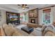 Cozy living room with a stone fireplace, large sectional sofa, and natural light at 317 Briarfield Dr, Apex, NC 27502