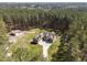 Expansive aerial view of the home, garage and surrounding land surrounded by dense, mature trees at 3220 Brassfield Rd, Creedmoor, NC 27522