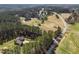 Expansive aerial view capturing the property's placement among trees, near a pond, and along a country road at 3220 Brassfield Rd, Creedmoor, NC 27522