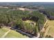 Stunning aerial view showcasing the home's private, wooded lot with a long driveway at 3220 Brassfield Rd, Creedmoor, NC 27522