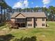 Expansive backyard view featuring a large deck and screened porch overlooking a lush green lawn at 3220 Brassfield Rd, Creedmoor, NC 27522
