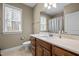 Bright bathroom featuring a wood vanity, neutral countertops and tile floor, and large window at 3220 Brassfield Rd, Creedmoor, NC 27522