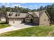 Charming exterior of home with well-manicured lawn, featuring a three car garage and a matching storage building at 3220 Brassfield Rd, Creedmoor, NC 27522