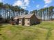 Rear exterior home view showing the patio, screened-in porch and large yard at 3220 Brassfield Rd, Creedmoor, NC 27522