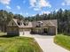 Charming home with a well-manicured lawn, three-car garage, stone accents, and mature trees at 3220 Brassfield Rd, Creedmoor, NC 27522