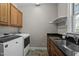Well-equipped laundry room with modern machines, dark granite countertops and a window at 3220 Brassfield Rd, Creedmoor, NC 27522