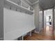 Bright mudroom featuring white bench with hooks and shelves and hardwood floors at 3220 Brassfield Rd, Creedmoor, NC 27522