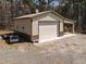 Exterior view of outbuilding, featuring a large drive-in door with additional storage capabilities at 3220 Brassfield Rd, Creedmoor, NC 27522