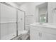 Bright bathroom featuring a glass-enclosed tiled shower and a white vanity with ample storage at 3849 Rosebush Dr, Zebulon, NC 27597