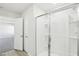 A glass shower with a white-tiled surround and a door leading to a bedroom space at 3849 Rosebush Dr, Zebulon, NC 27597