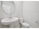 Modern half-bathroom featuring a pedestal sink, toilet, and neutral walls at 3849 Rosebush Dr, Zebulon, NC 27597