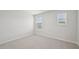 Sunlit bedroom with two windows featuring blinds and neutral carpet at 3849 Rosebush Dr, Zebulon, NC 27597