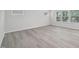 Bright bedroom featuring large windows, modern blinds, neutral walls, and stylish wood flooring at 3849 Rosebush Dr, Zebulon, NC 27597