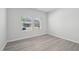 Empty bedroom with neutral walls, two windows with blinds, and modern wood-look flooring at 3849 Rosebush Dr, Zebulon, NC 27597