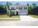 Charming two-story home featuring a two-car garage, manicured lawn, and inviting covered entry at 3849 Rosebush Dr, Zebulon, NC 27597