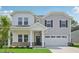 Charming two-story home featuring a covered porch, two-car garage, and a beautifully landscaped front yard at 3849 Rosebush Dr, Zebulon, NC 27597