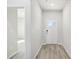 Bright hallway with light gray plank flooring and white trim at 3849 Rosebush Dr, Zebulon, NC 27597