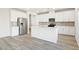 Modern kitchen showcasing white cabinetry, a stainless steel refrigerator, and a center island with seating at 3849 Rosebush Dr, Zebulon, NC 27597