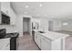 Open-concept kitchen with a large island, stainless steel appliances, and modern white cabinets at 3849 Rosebush Dr, Zebulon, NC 27597