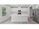 Contemporary kitchen with white cabinets, stainless steel appliances, large island, and wood-look flooring at 3849 Rosebush Dr, Zebulon, NC 27597