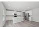 Modern kitchen with white cabinets, stainless steel appliances, an island, and hardwood floors at 3849 Rosebush Dr, Zebulon, NC 27597