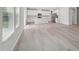 Spacious open-concept living area with hardwood floors and a modern kitchen featuring stainless steel appliances at 3849 Rosebush Dr, Zebulon, NC 27597