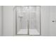 Modern bathroom shower featuring glass doors, gray tile, and bright lighting at 3849 Rosebush Dr, Zebulon, NC 27597