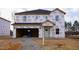 Unfinished two-story home with attached two-car garage, Tyvek HomeWrap, and dark roof shingles at 3857 Rosebush Dr, Zebulon, NC 27597
