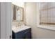 Bathroom featuring a blue vanity with white countertop, a mirror, and a window with blinds at 45 Melody Dr, Youngsville, NC 27596
