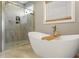 Elegant bathroom features a large soaking tub, glass enclosed shower, and a modern window at 45 Melody Dr, Youngsville, NC 27596