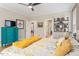 A spacious bedroom is complete with a ceiling fan, TV, and eye-catching turquoise chest at 45 Melody Dr, Youngsville, NC 27596