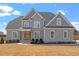 Beautiful two-story home with a grey exterior, manicured lawn, and inviting front porch showcasing curb appeal at 45 Melody Dr, Youngsville, NC 27596
