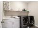 Well-organized laundry room features a sleek countertop, washer, dryer, and ample storage at 45 Melody Dr, Youngsville, NC 27596