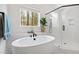 Bright bathroom featuring a soaking tub, black fixtures and a glass enclosed shower at 5004 Lakemont Dr, Raleigh, NC 27609