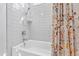 Bright bathroom features a tub with white subway tile and a colorful patterned shower curtain at 5004 Lakemont Dr, Raleigh, NC 27609