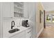 Butler's pantry features a bar sink, quartz countertops, designer tile backsplash and white cabinets at 5004 Lakemont Dr, Raleigh, NC 27609