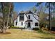 Charming white Tudor-style home with manicured landscaping and a welcoming front entrance at 5004 Lakemont Dr, Raleigh, NC 27609