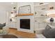 Elegant fireplace with a white brick surround, wood mantel, and custom built-in shelving at 5004 Lakemont Dr, Raleigh, NC 27609