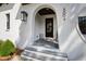 Inviting front porch with stone steps and an arched entry featuring a dark wood door at 5004 Lakemont Dr, Raleigh, NC 27609