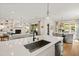 Bright open kitchen with stainless steel sink and light wood floors adjoins living and dining areas at 5004 Lakemont Dr, Raleigh, NC 27609