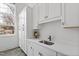 Modern laundry room boasts ample storage, a sink, and stylish herringbone floors at 5004 Lakemont Dr, Raleigh, NC 27609