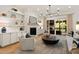 Bright living room featuring a fireplace, white brick accent wall, and seamless indoor-outdoor flow at 5004 Lakemont Dr, Raleigh, NC 27609