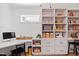 Functional office space with custom built-in shelving, a desk, a sleek computer, and a comfortable black chair at 5004 Lakemont Dr, Raleigh, NC 27609