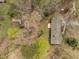 Aerial shot of a property featuring a house, outbuilding, mature trees, and an expansive yard at 5130 Guess Rd, Durham, NC 27712