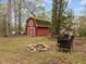 Well-maintained backyard with a fire pit, seating, a storage shed, and mature trees at 5130 Guess Rd, Durham, NC 27712