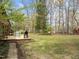 Lush backyard with a deck, mature trees, and ample space for outdoor activities and recreation at 5130 Guess Rd, Durham, NC 27712