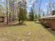 Spacious backyard with mature trees, deck, hammock, and a well-maintained lawn, perfect for outdoor living at 5130 Guess Rd, Durham, NC 27712