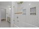 Bright bathroom with white subway tile shower, decorative niche, glass door, and black and white patterned tile floor at 5130 Guess Rd, Durham, NC 27712