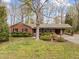 Charming brick home featuring mature trees, covered parking, and lush landscaping at 5130 Guess Rd, Durham, NC 27712